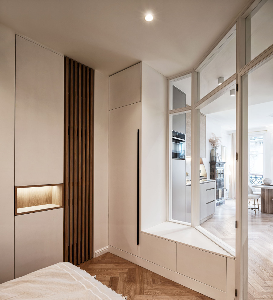 Small transitional bedroom in Paris with light hardwood floors.