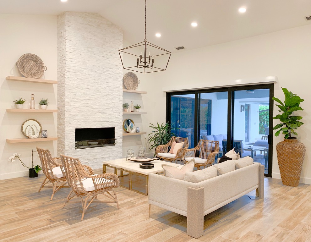 This is an example of a contemporary formal open concept living room in Miami with white walls, light hardwood floors, a ribbon fireplace, a stone fireplace surround, no tv and beige floor.