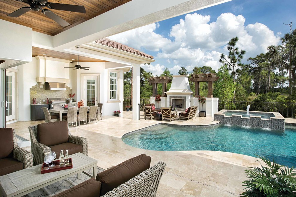 Photo of a mid-sized mediterranean backyard custom-shaped pool in Orlando with a water feature and natural stone pavers.