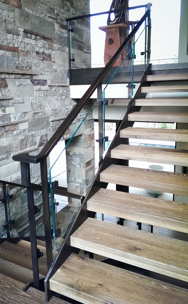 Photo of a mid-sized contemporary wood staircase in Salt Lake City with open risers and glass railing.