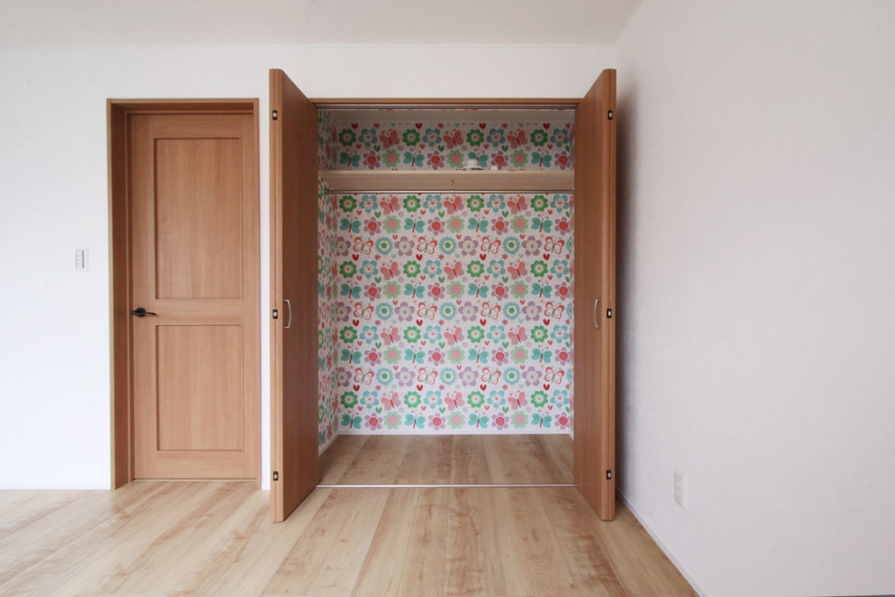 Mid-sized women's built-in wardrobe with flat-panel cabinets, medium wood cabinets, plywood floors and beige floor.