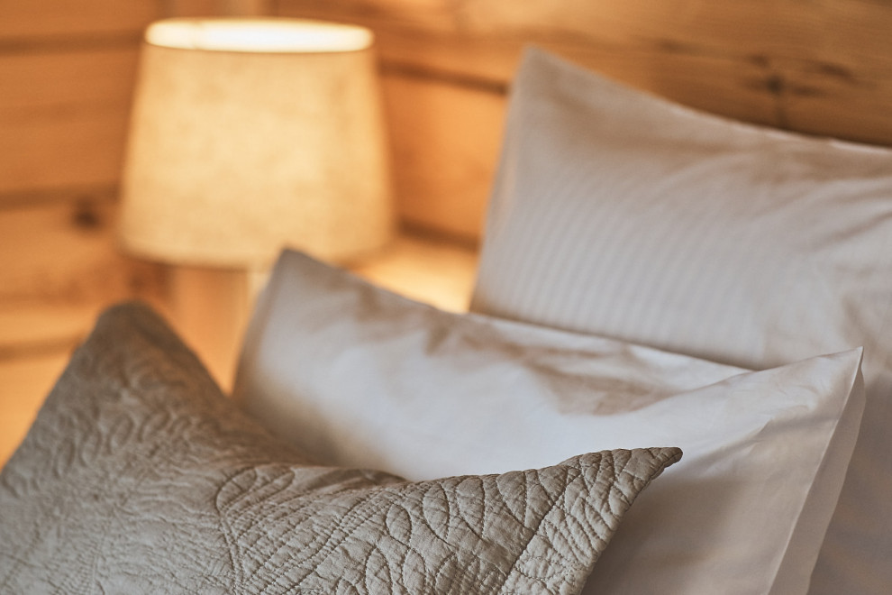 На фото: гостевая спальня среднего размера, (комната для гостей), в белых тонах с отделкой деревом: освещение в стиле фьюжн с бежевыми стенами, деревянным полом, бежевым полом, деревянным потолком и деревянными стенами
