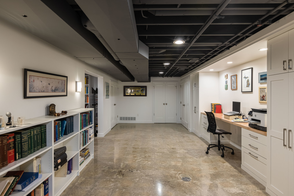 Inspiration for a mid-sized transitional underground concrete floor, exposed beam and beige floor basement remodel in Detroit with white walls