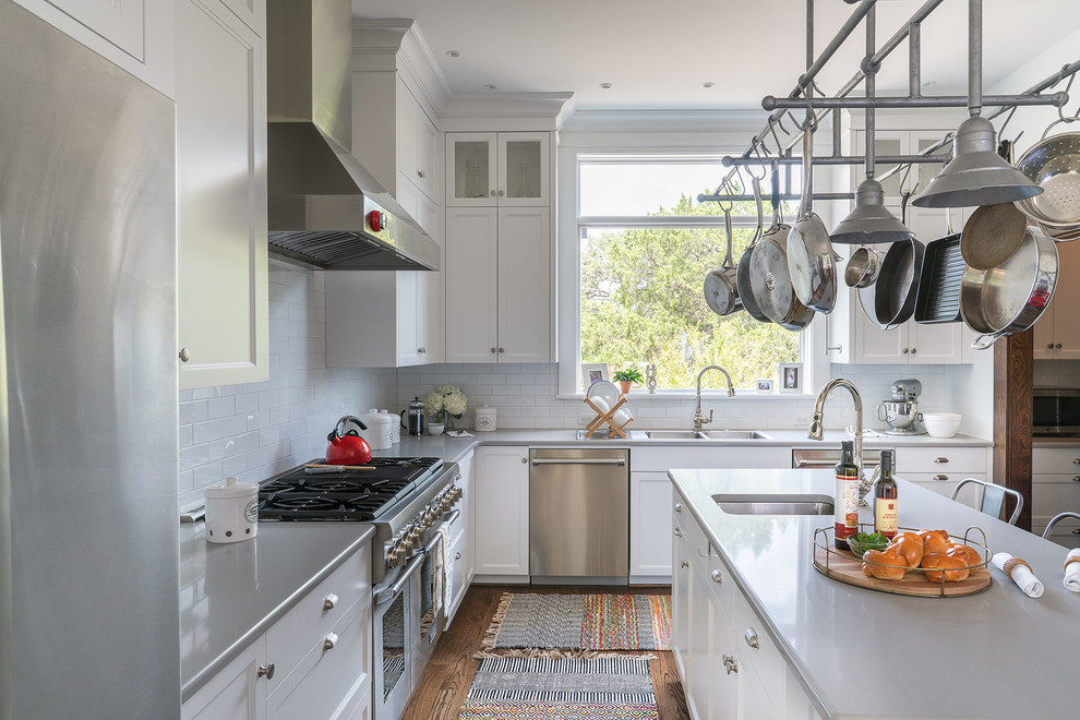 Design ideas for a mid-sized traditional kitchen in Austin with recessed-panel cabinets, white cabinets, subway tile splashback, stainless steel appliances, with island, brown floor, a double-bowl sink, quartz benchtops, white splashback, dark hardwood floors and grey benchtop.