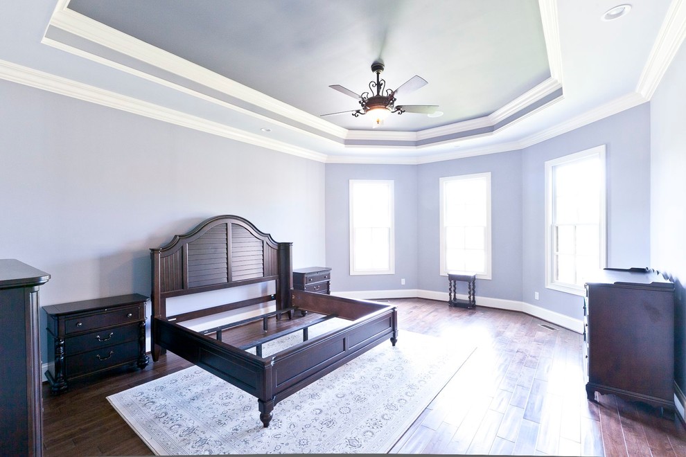 Large loft-style bedroom in Louisville with purple walls and dark hardwood floors.