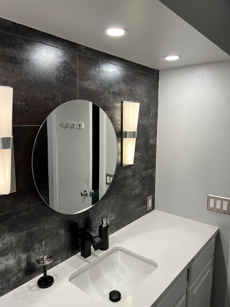 Photo of a mid-sized modern 3/4 bathroom in Phoenix with flat-panel cabinets, white cabinets, black tile, ceramic tile, black walls, an undermount sink, engineered quartz benchtops, white benchtops, a single vanity and a built-in vanity.