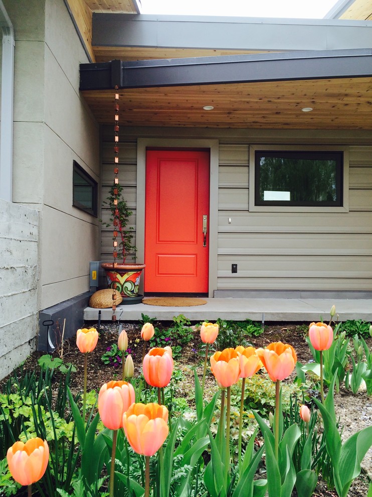 Photo of a mid-sized eclectic entryway in Other with a single front door and a red front door.