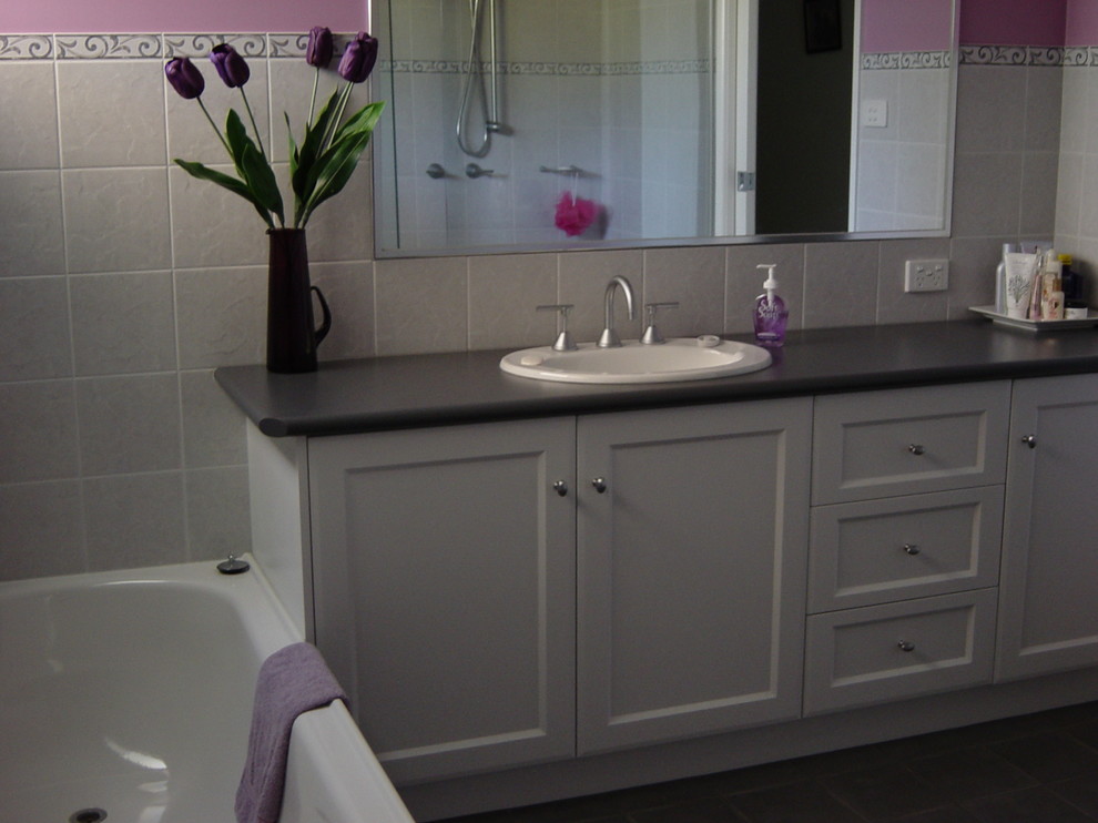 Contemporary bathroom in Melbourne with white cabinets.