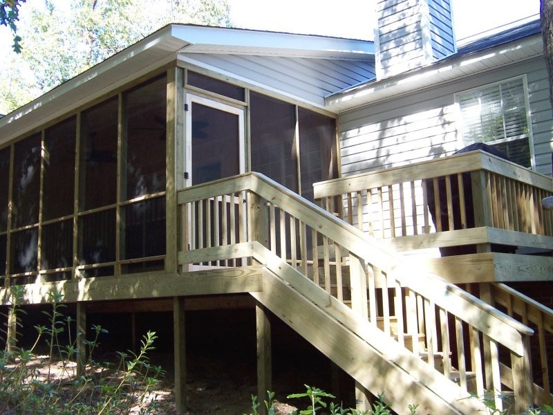 Mid-sized mountain style backyard deck photo with a roof extension