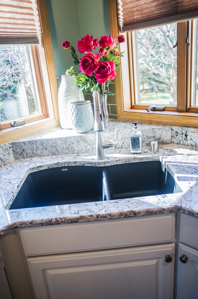 Inspiration for a small transitional u-shaped ceramic tile eat-in kitchen remodel with a drop-in sink, raised-panel cabinets, white cabinets, granite countertops, brown backsplash, porcelain backsplash, white appliances and an island