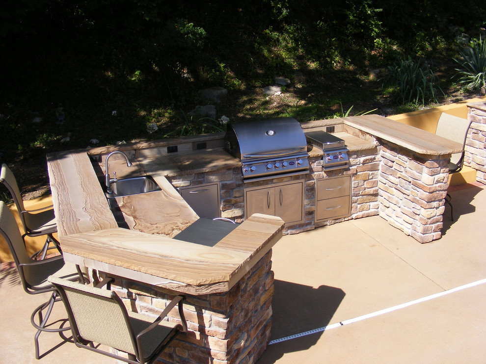 Design ideas for a large arts and crafts backyard patio in St Louis with an outdoor kitchen and concrete slab.