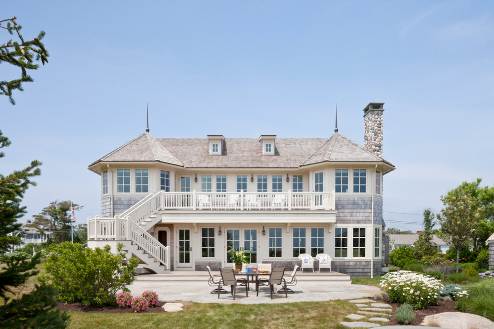 Inspiration for a large beach style three-storey beige house exterior in Boston with wood siding and a shingle roof.