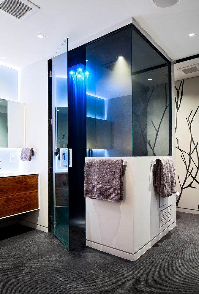 Inspiration for a large contemporary master bathroom in Vancouver with flat-panel cabinets, medium wood cabinets, a freestanding tub, an alcove shower, a one-piece toilet, gray tile, porcelain tile, an undermount sink and solid surface benchtops.