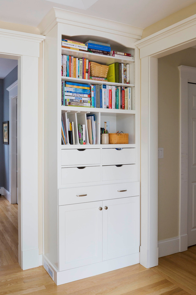 Large transitional l-shaped light wood floor kitchen photo in Boston with a farmhouse sink, recessed-panel cabinets, white cabinets, quartz countertops, white backsplash, subway tile backsplash, stainless steel appliances and an island