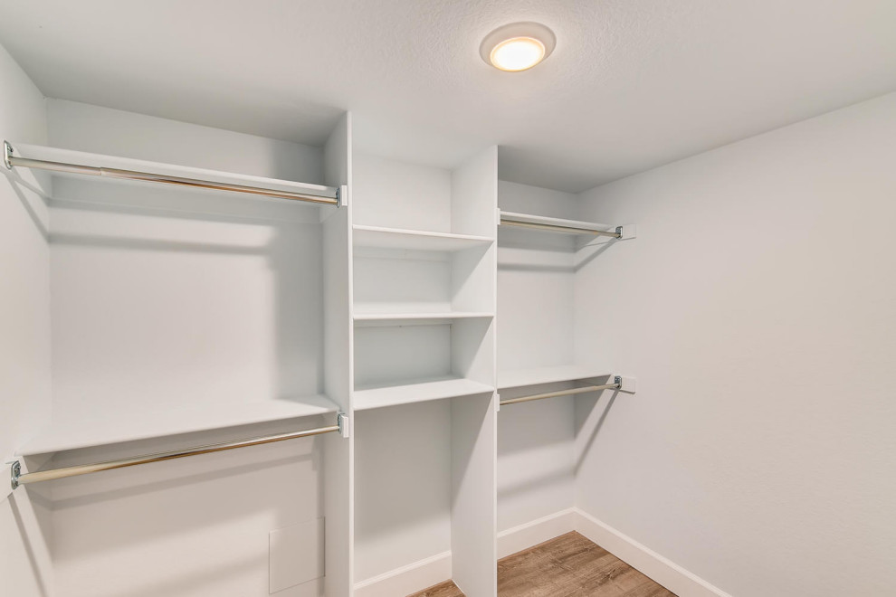 Inspiration for a mid-sized contemporary walk-in wardrobe in Denver with white cabinets and laminate floors.