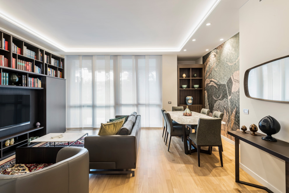 This is an example of a large contemporary formal open concept living room in Milan with white walls, light hardwood floors, no fireplace, a built-in media wall, brown floor, recessed and wallpaper.