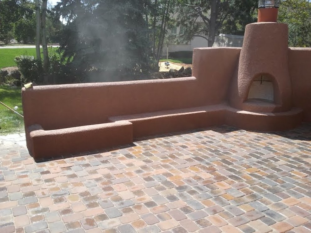 Inspiration for a mid-sized backyard patio in Denver with a fire feature, brick pavers and no cover.