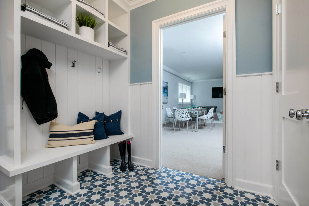 Inspiration for a mid-sized transitional mudroom in New York with blue walls, concrete floors, a single front door, a white front door and multi-coloured floor.