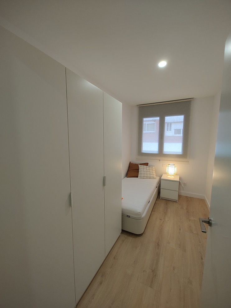Imagen de dormitorio infantil nórdico de tamaño medio con paredes blancas, suelo de madera clara y suelo marrón