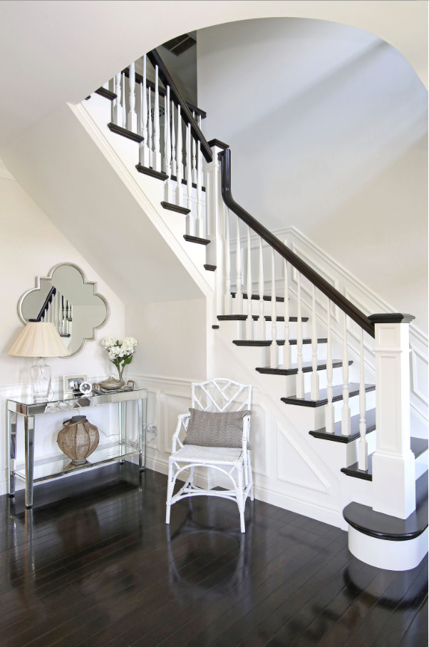 This is an example of a transitional foyer in Boston with white walls and dark hardwood floors.