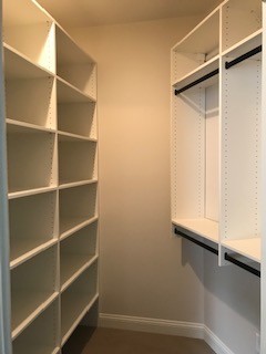 This storage room has all adjustable shelving along one wall with double hanger rods along the other. This room doubles as a pantry and coat closet. What a great use of space!