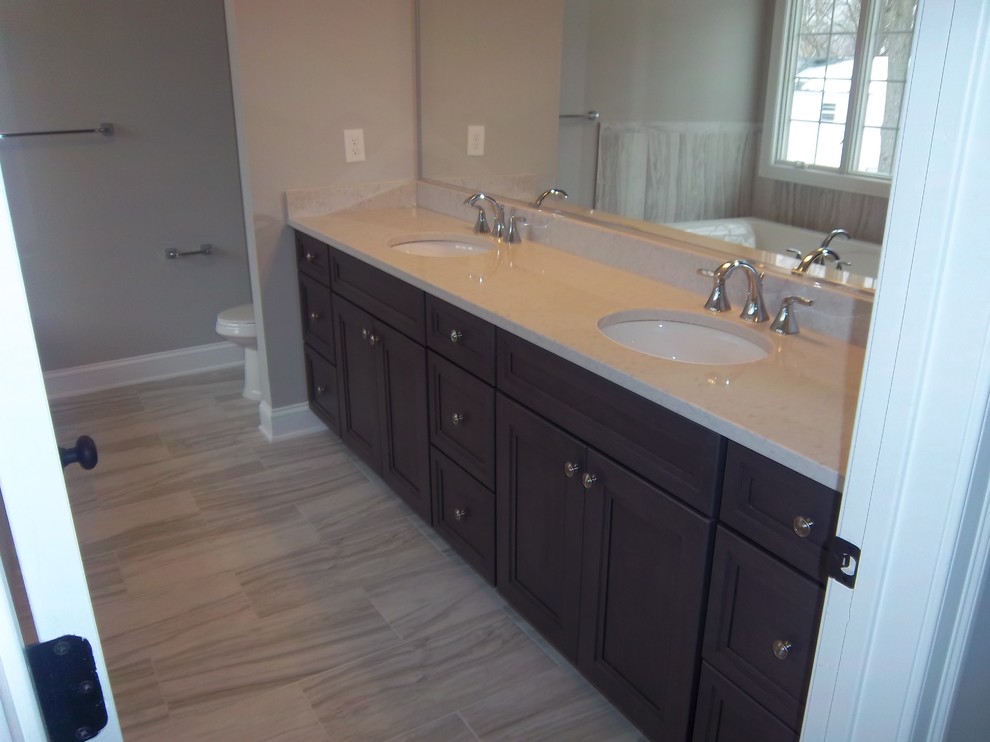 Mid-sized transitional master porcelain tile porcelain tile and beige floor alcove bathtub photo with beige walls, an undermount sink, recessed-panel cabinets, dark wood cabinets, granite countertops and beige countertops