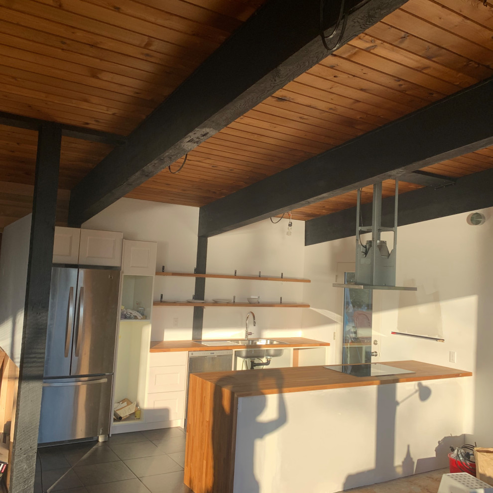 Example of a minimalist kitchen design in Vancouver with brown countertops