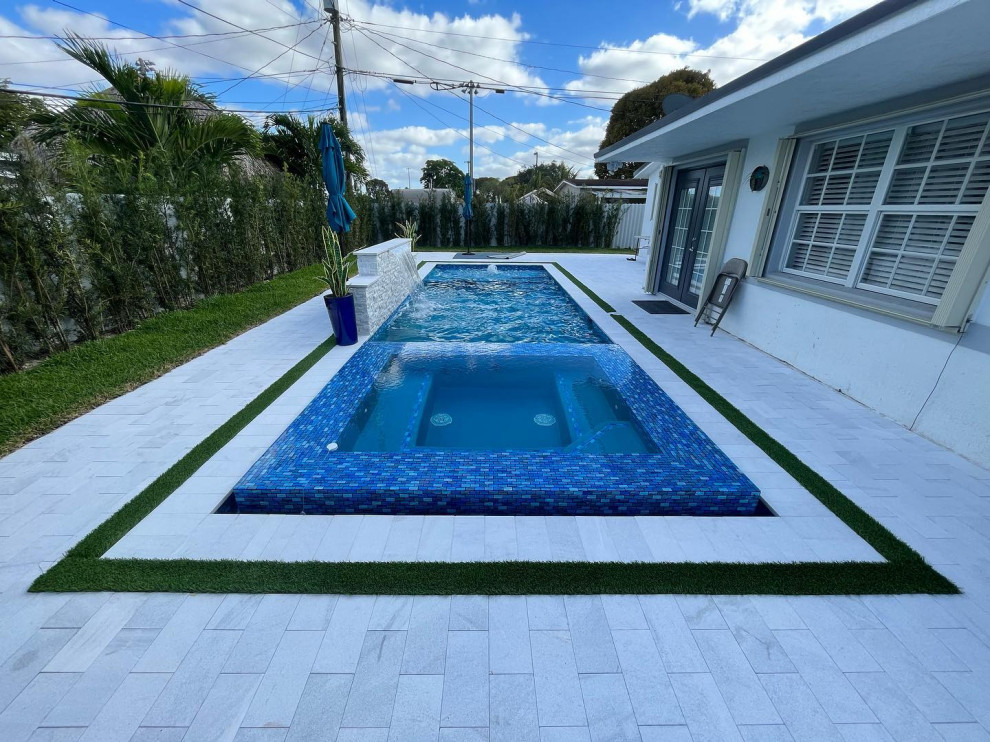 Foto di una piccola piscina tropicale personalizzata dietro casa con una vasca idromassaggio e pavimentazioni in pietra naturale