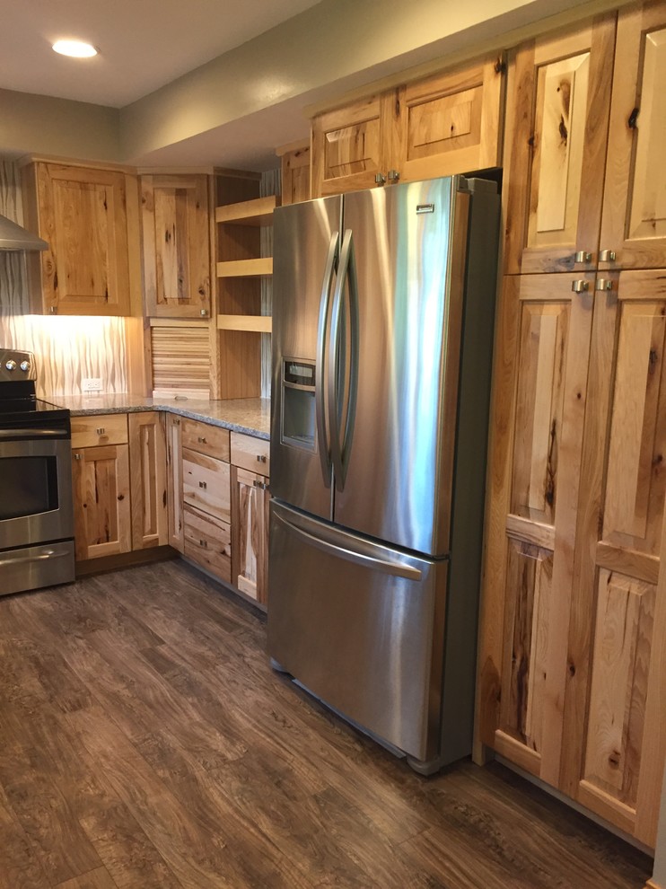 Example of a mid-sized mountain style u-shaped laminate floor and brown floor eat-in kitchen design in Omaha with an undermount sink, raised-panel cabinets, light wood cabinets, quartz countertops, beige backsplash, porcelain backsplash, stainless steel appliances, an island and gray countertops