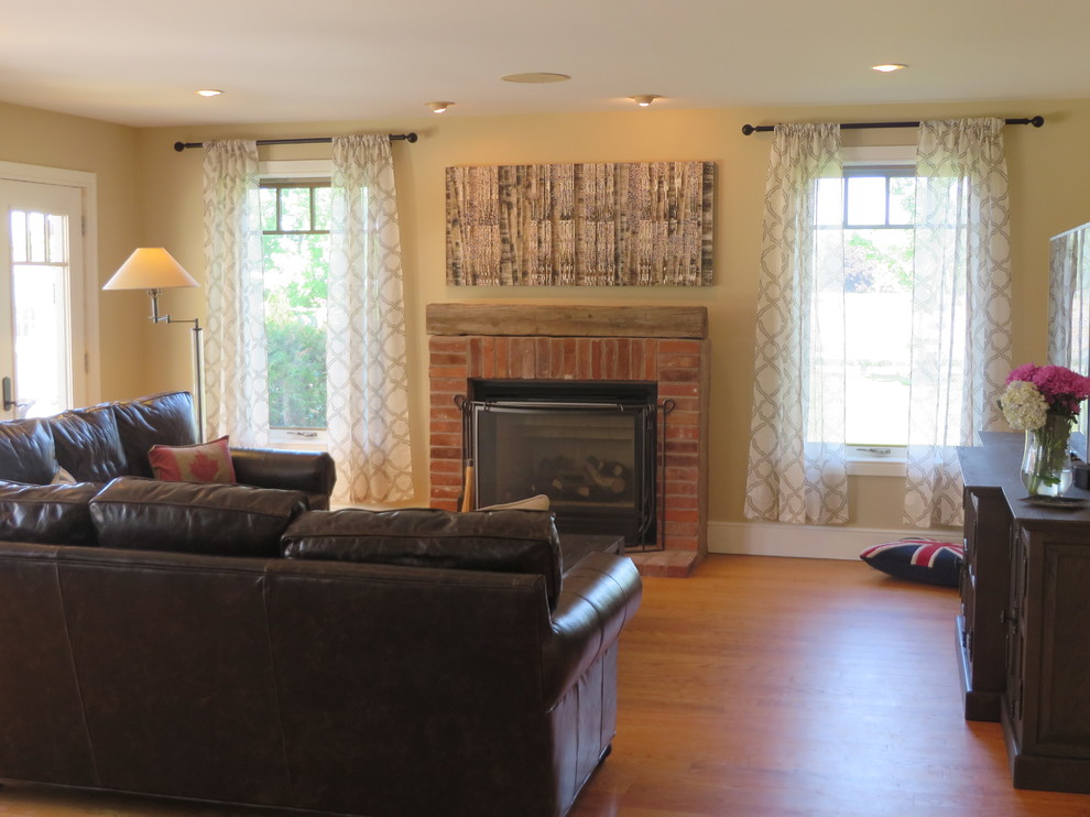 Photo of a large country open concept living room in Toronto with beige walls, medium hardwood floors, a standard fireplace and a brick fireplace surround.