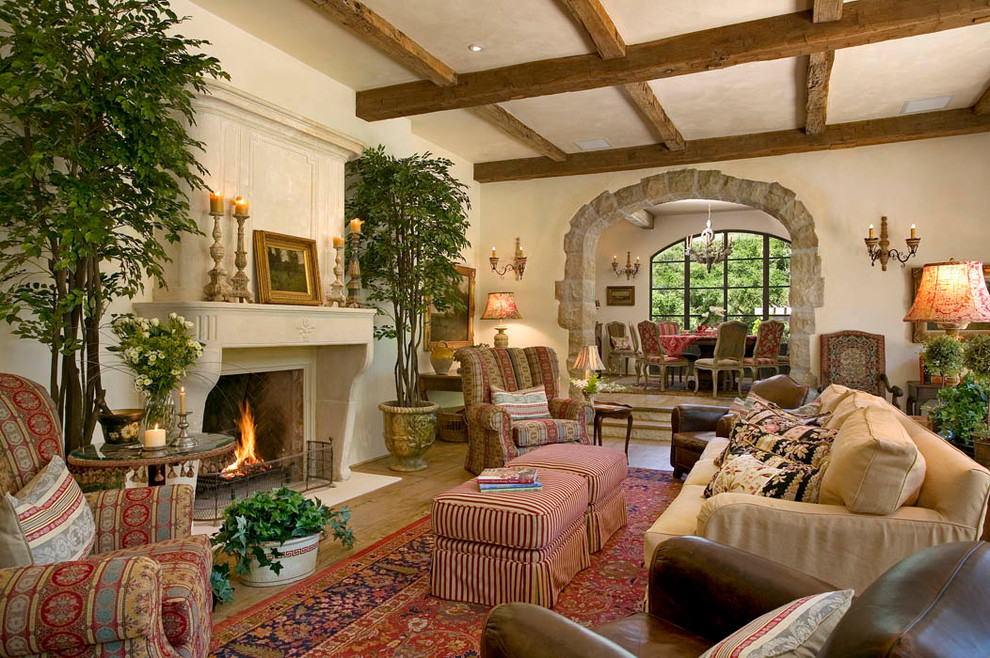 Design ideas for a mid-sized mediterranean formal open concept living room in New York with beige walls, medium hardwood floors, a standard fireplace, a stone fireplace surround and no tv.