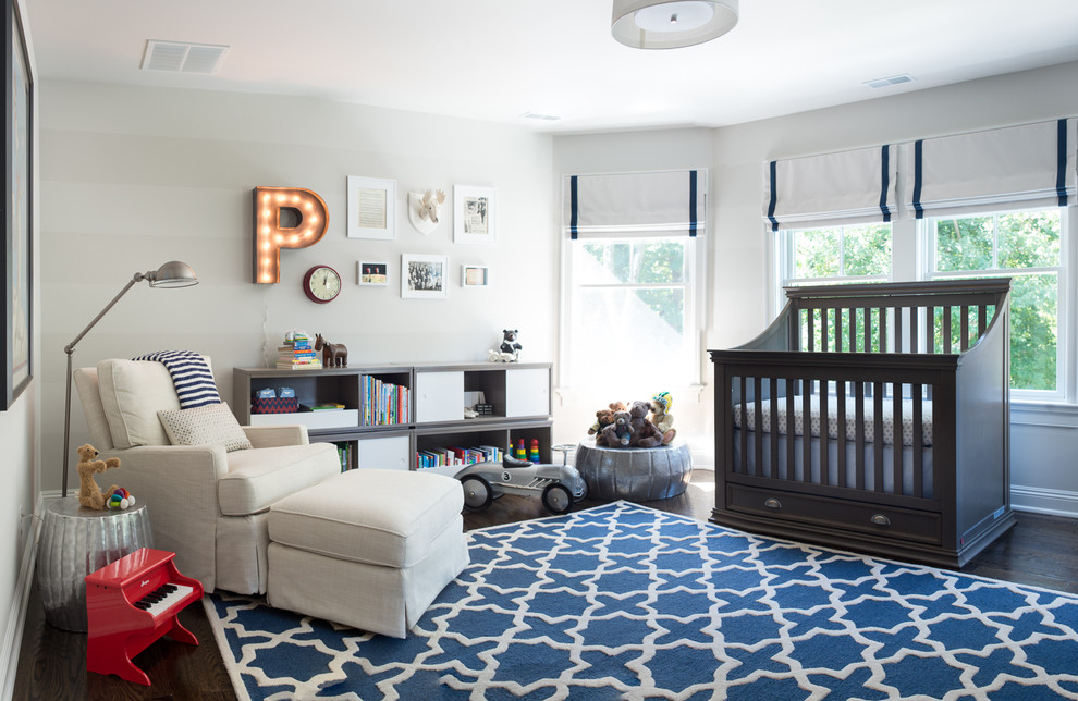 Transitional nursery in New York with grey walls and dark hardwood floors for boys.