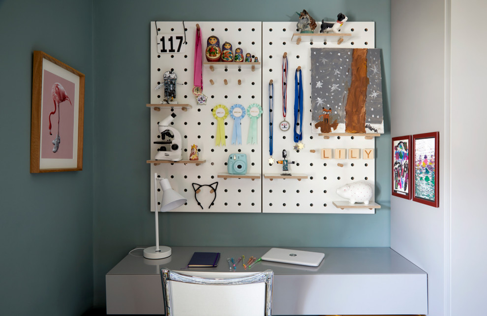 This is an example of a small modern gender-neutral kids' bedroom for kids 4-10 years old in London with blue walls and carpet.