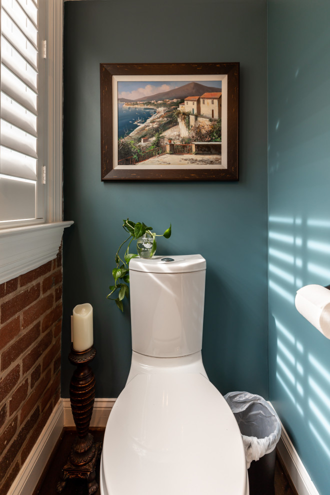 This is an example of a large contemporary powder room in DC Metro with glass-front cabinets, white cabinets, dark hardwood floors and brown floor.