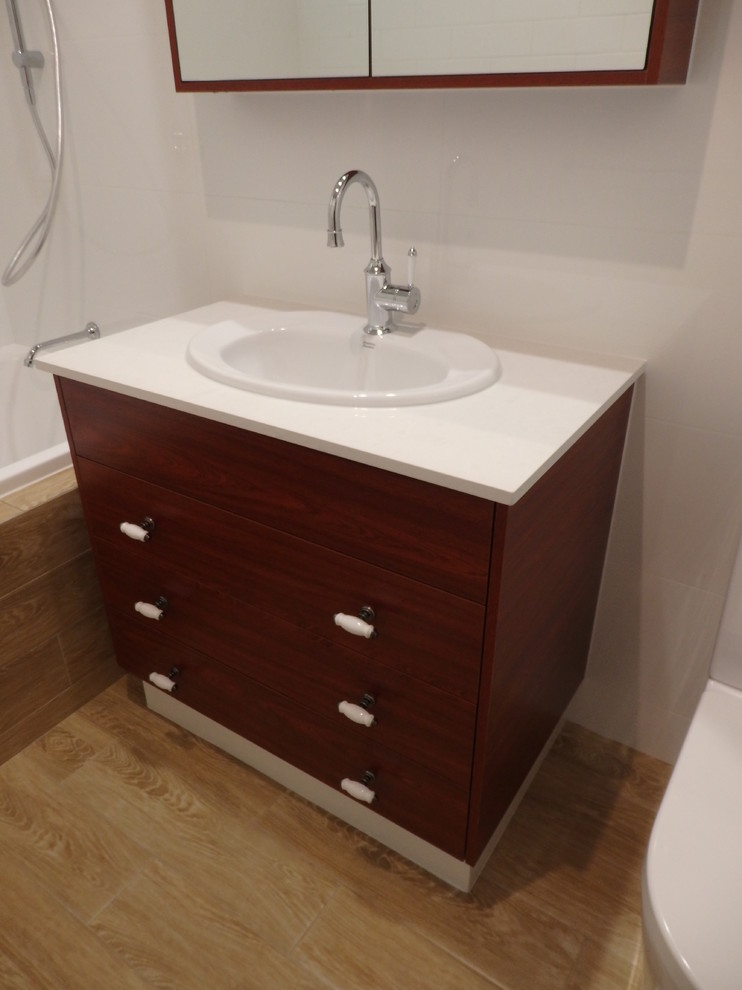 Traditional bathroom in Perth with flat-panel cabinets, medium wood cabinets, a shower/bathtub combo, a drop-in sink and engineered quartz benchtops.