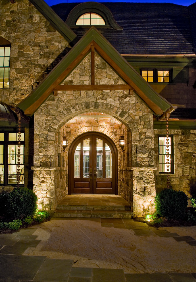 Example of a large transitional front door design with a dark wood front door