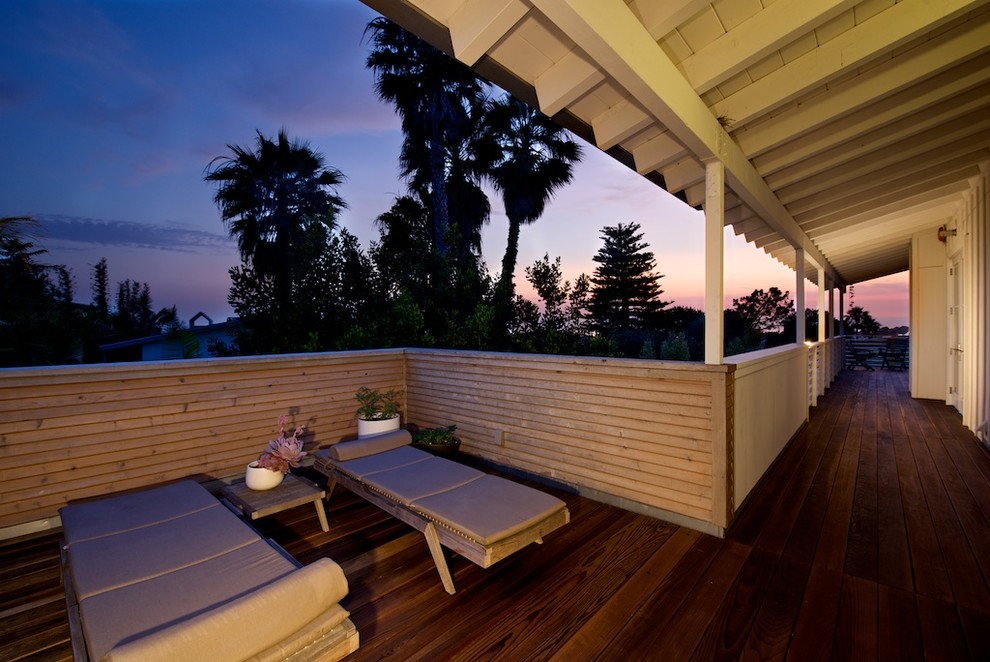 This is an example of a beach style deck in San Diego with a roof extension.