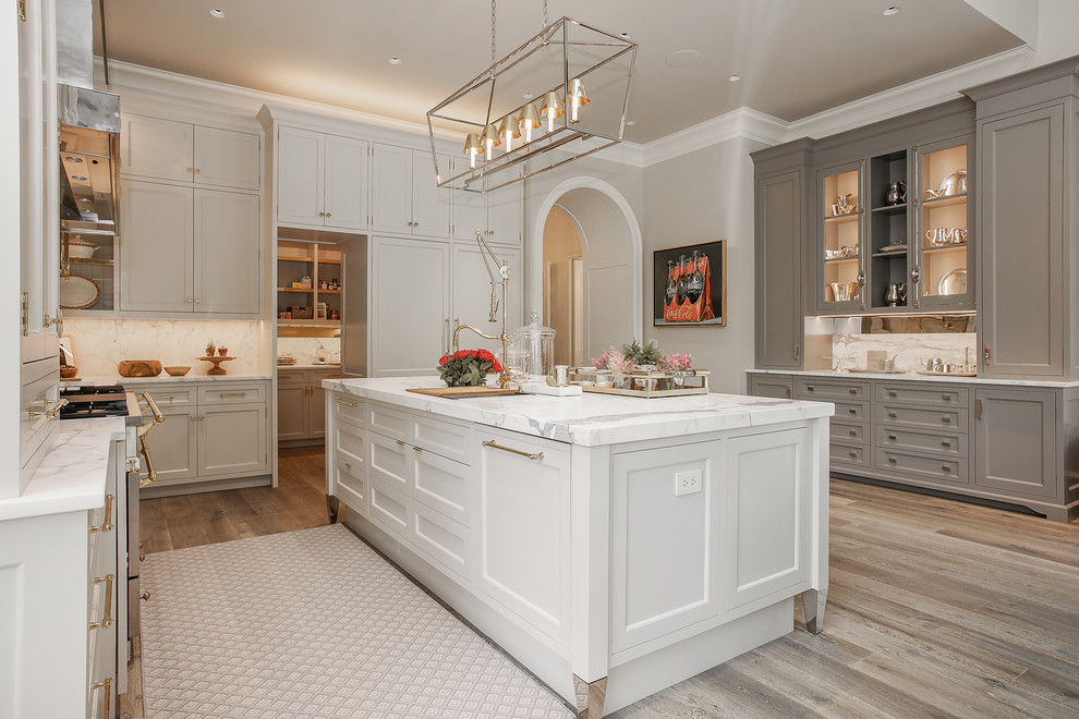 Traditional l-shaped kitchen in Chicago with recessed-panel cabinets, grey cabinets, white splashback, stainless steel appliances, dark hardwood floors and brown floor.