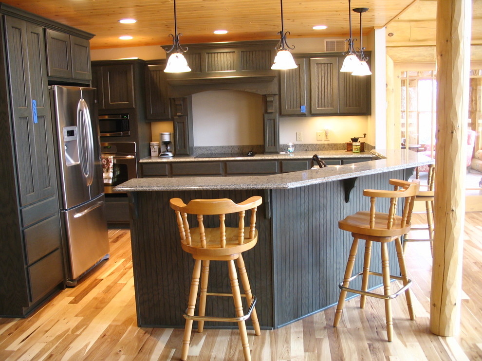 Inspiration for a mid-sized rustic l-shaped light wood floor and beige floor enclosed kitchen remodel with raised-panel cabinets, gray cabinets, granite countertops, stainless steel appliances and an island