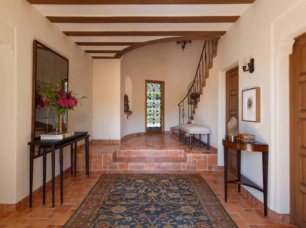 Photo of a mediterranean entryway in San Francisco with white walls and terra-cotta floors.