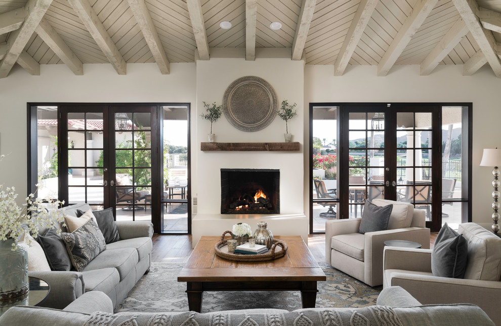 Tuscan formal medium tone wood floor living room photo in Phoenix with a standard fireplace and white walls