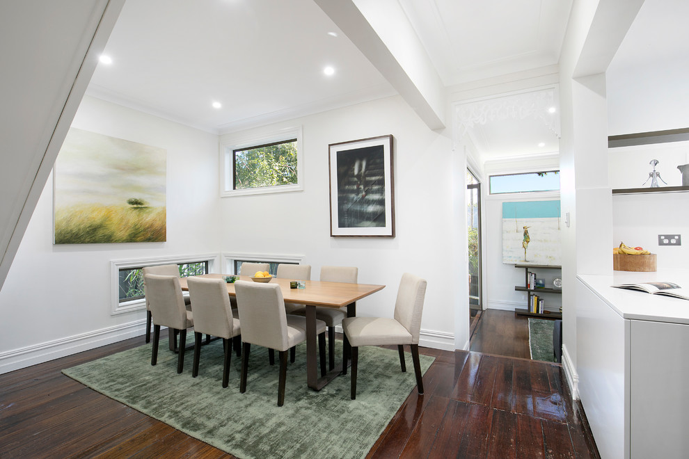 Photo of a mid-sized transitional open plan dining in Sydney with white walls, dark hardwood floors, no fireplace and brown floor.
