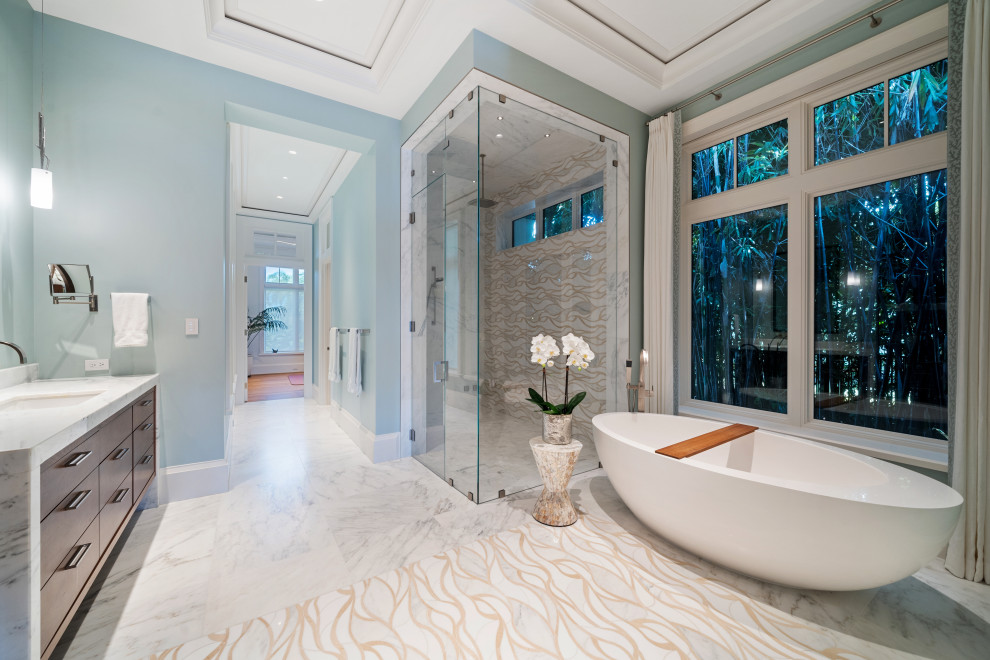 Modernes Badezimmer En Suite mit hellbraunen Holzschränken, freistehender Badewanne, Eckdusche, farbigen Fliesen, buntem Boden, Falttür-Duschabtrennung und weißer Waschtischplatte in Miami