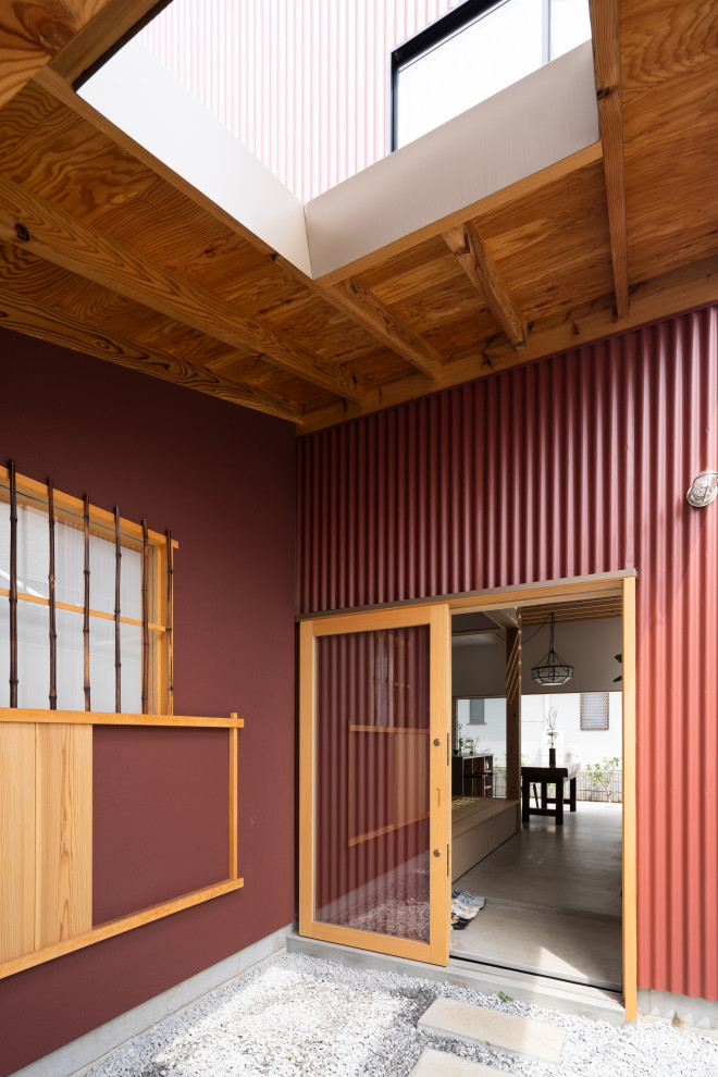Ispirazione per la villa piccola rossa a due piani con copertura in metallo o lamiera e tetto rosso