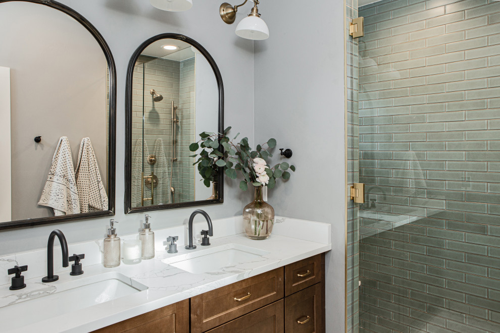 This is an example of a mid-sized traditional master bathroom in Denver with shaker cabinets, medium wood cabinets, an alcove shower, a two-piece toilet, blue tile, ceramic tile, grey walls, ceramic floors, an undermount sink, engineered quartz benchtops, beige floor, a hinged shower door, white benchtops, a shower seat, a double vanity, a built-in vanity and vaulted.