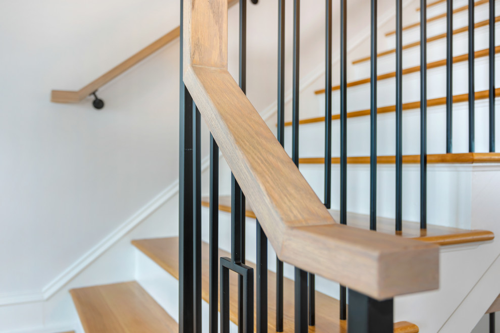 Ejemplo de escalera en L costera de tamaño medio con escalones de madera, contrahuellas de madera y barandilla de metal