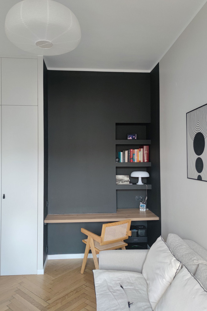 Immagine di un ufficio minimalista con pareti nere e scrivania incassata