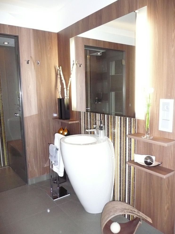 Badezimmer En Suite mit flächenbündigen Schrankfronten, hellbraunen Holzschränken, farbigen Fliesen, Glasfliesen, bunten Wänden, Keramikboden, Trogwaschbecken und gefliestem Waschtisch in Berlin