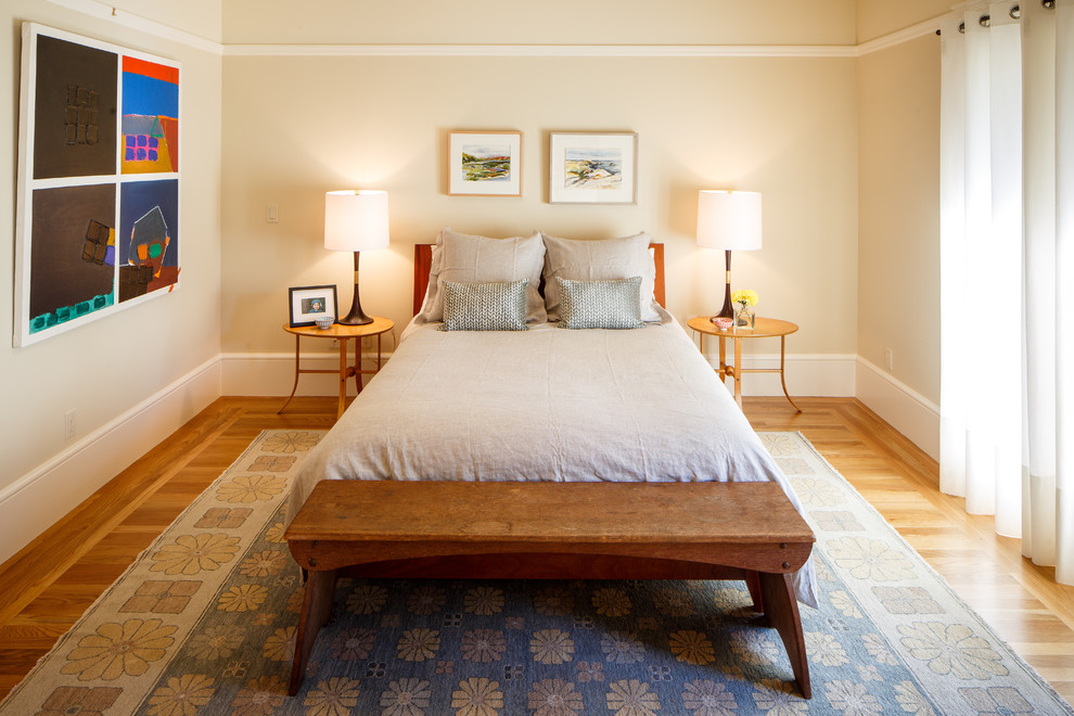This is an example of a mid-sized transitional master bedroom in San Francisco with beige walls and light hardwood floors.