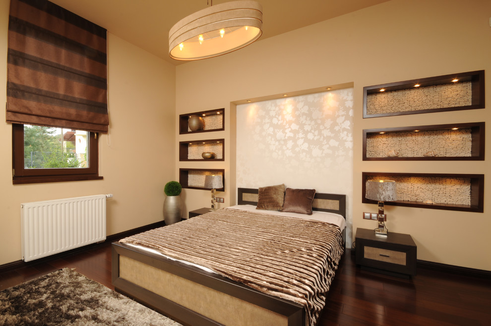 This is an example of a contemporary bedroom with beige walls and dark hardwood floors.